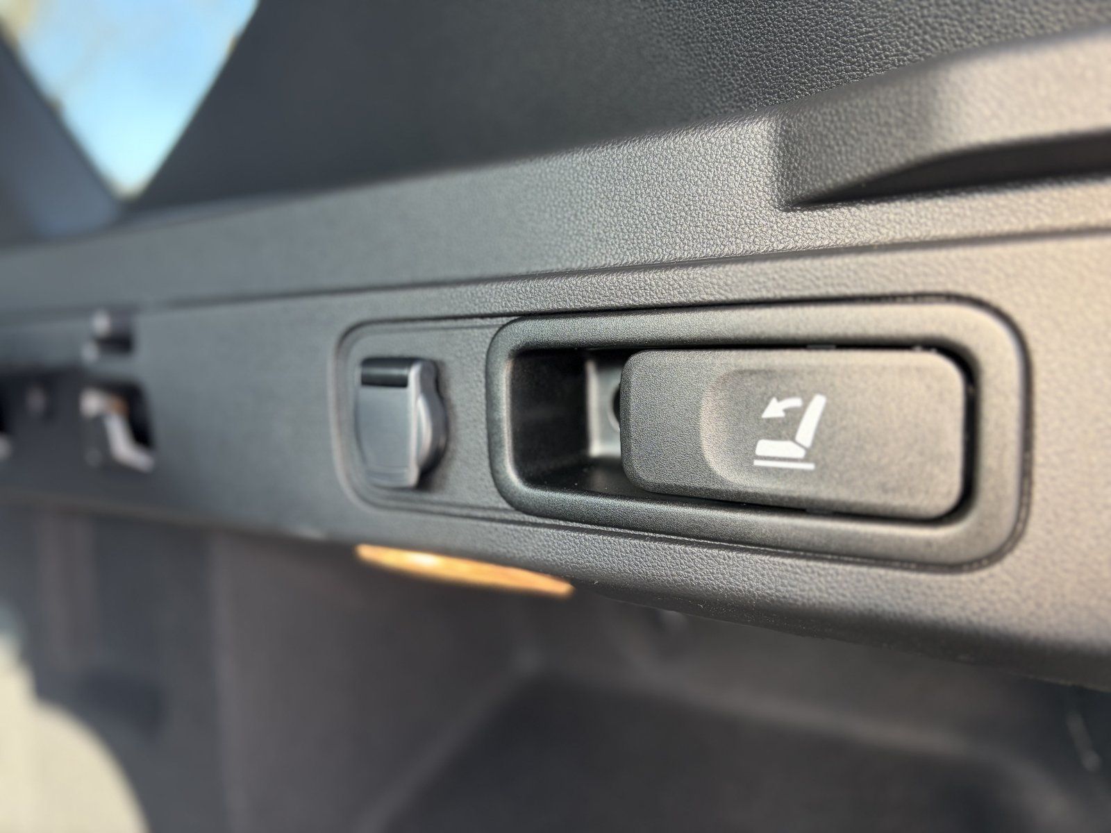 Detailaufnahme Kofferraum-Bedienelemente mit Sitzverstellung und Entriegelungsknopf im Fahrzeug
