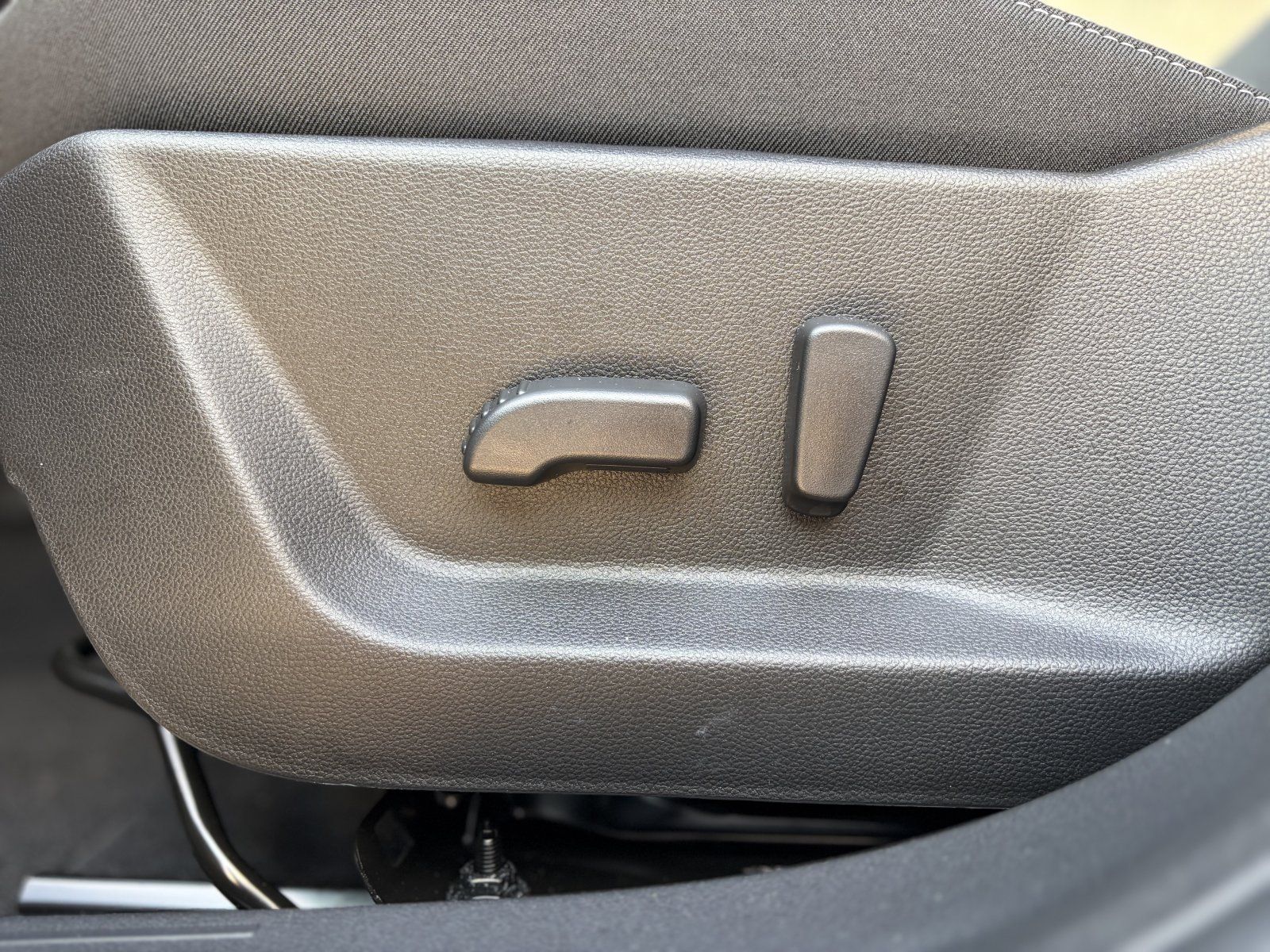 Detailaufnahme der manuellen Sitzverstellhebel an der Seitenwange eines Fahrzeugsitzes