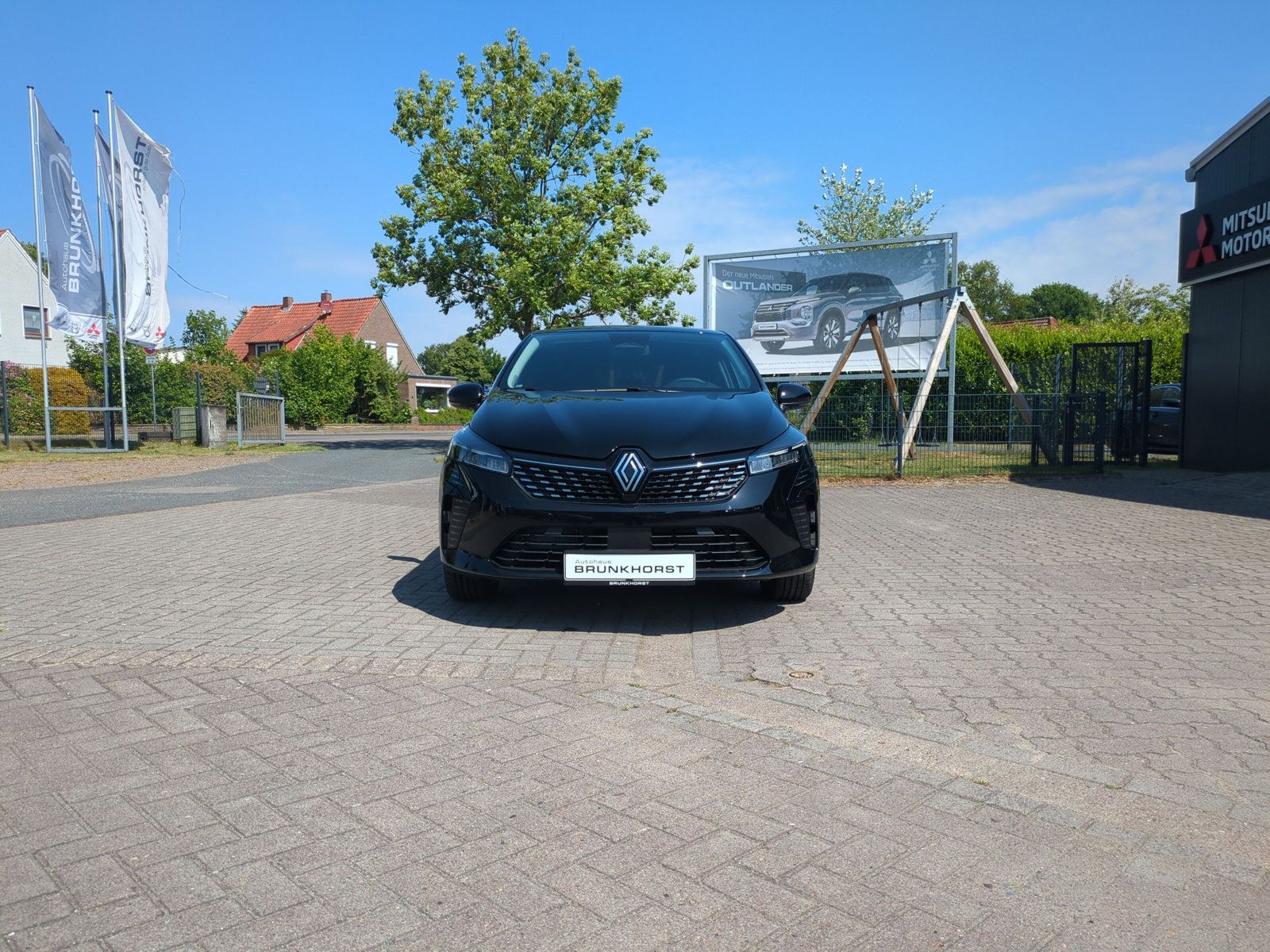 Schwarzer Renault Neuwagen in modernem Autohaus Brunkhorst Showroom mit großen Glasfenstern und eleganter Beleuchtung