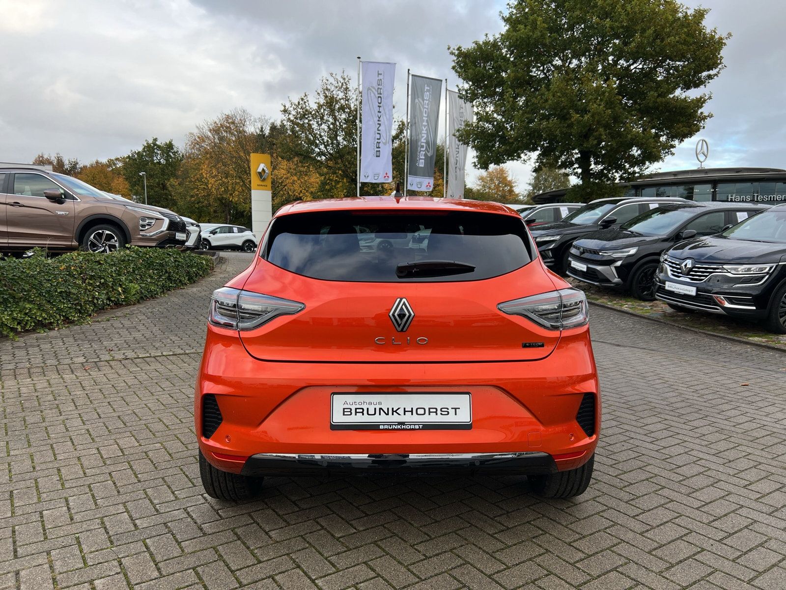 Orangefarbener Renault Clio Heckansicht im Autohaus Brunkhorst Showroom mit modernem Interieur und großen Fensterfronten