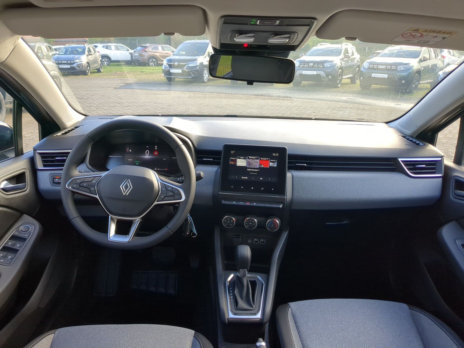 Dunkelgrüner Renault Clio Neuwagen im modernen Autohaus-Showroom mit großen Fenstern und eleganter Ausstellungsfläche