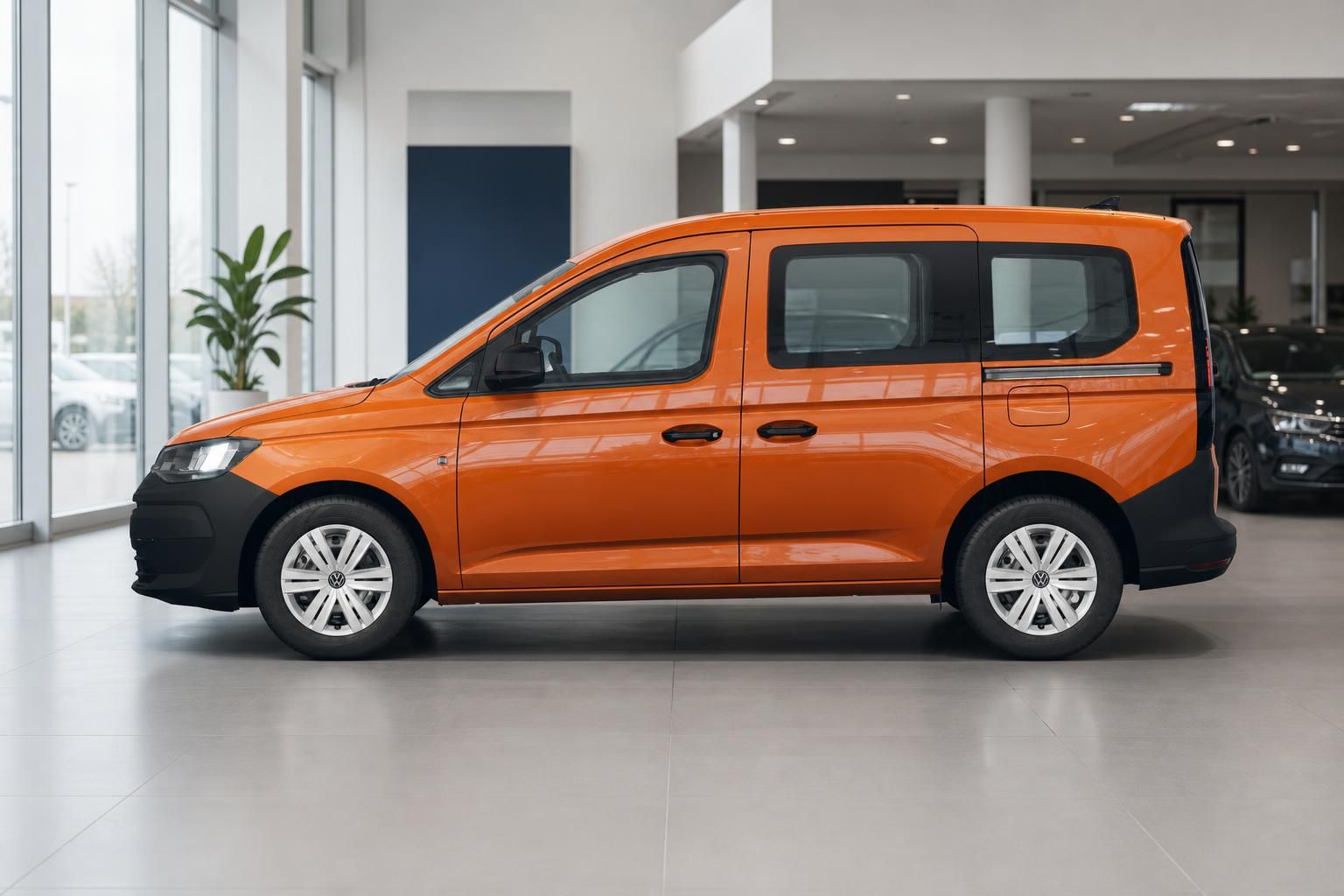 VW Caddy in Orange Seitenprofil im Autohaus