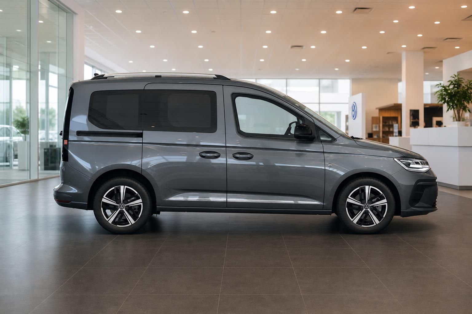 VW Caddy grau Seitenansicht im Autohaus Showroom