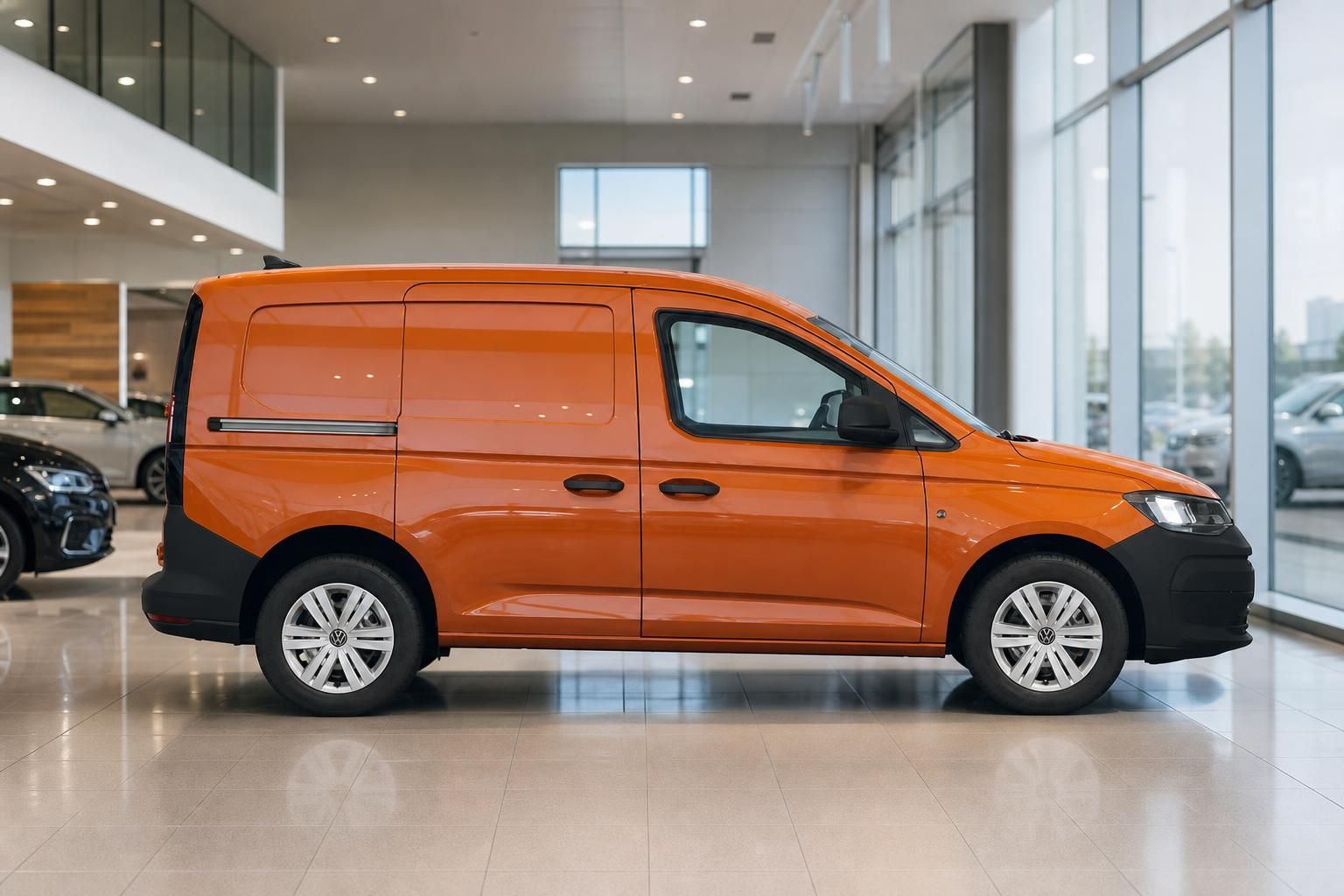 VW Caddy orange Transporter Seitenansicht im Showroom