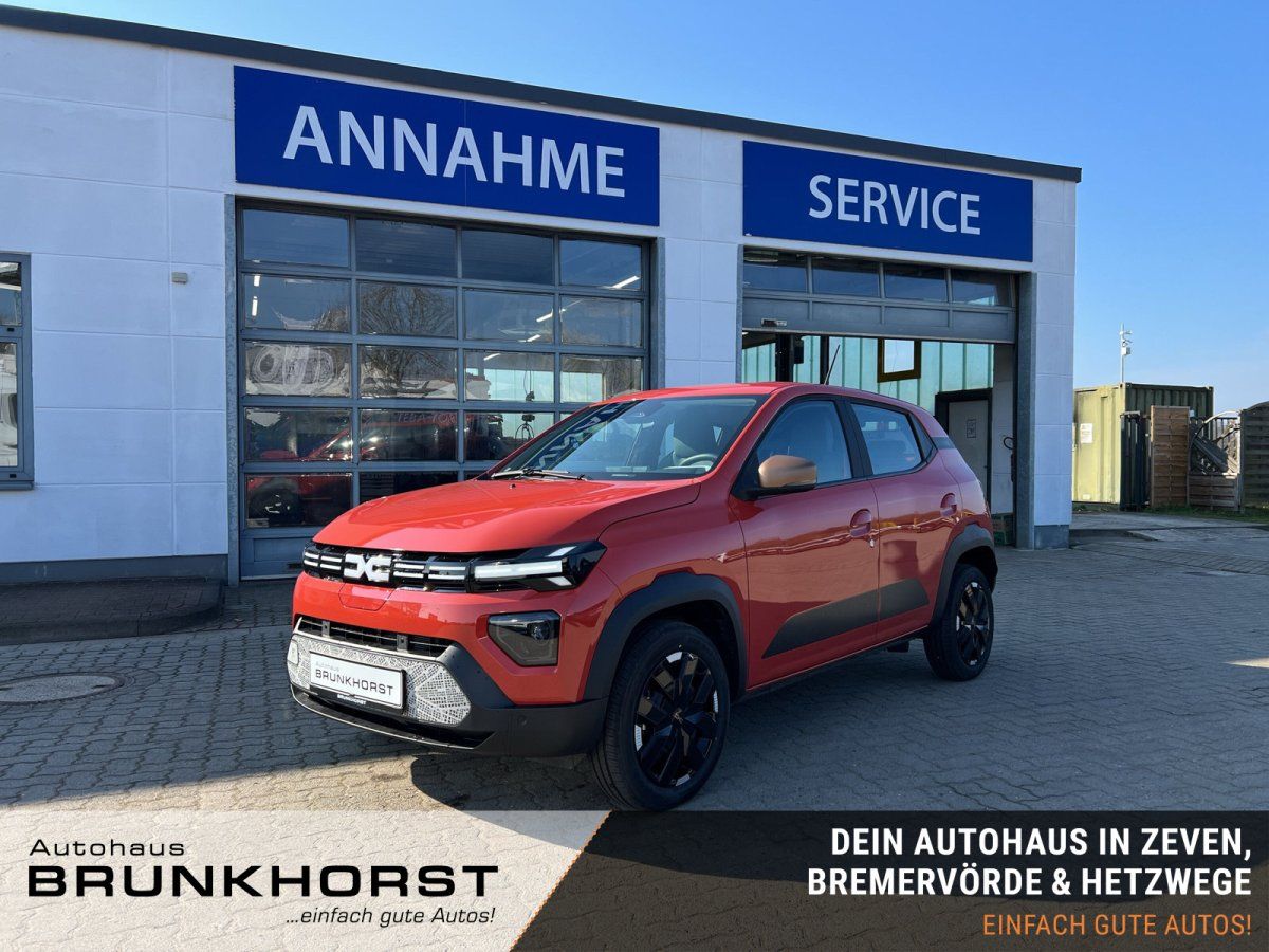 Dacia Spring Elektroauto in Orange im Autohaus Showroom - Kompakt-SUV von der Seite