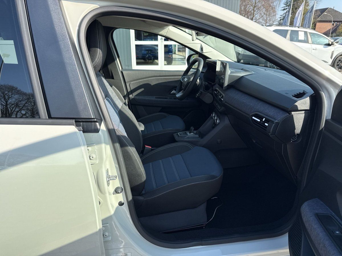 Innenraum eines weißen Fahrzeugs mit schwarzen Sitzen, Blick auf Fahrer- und Beifahrersitz im Autohaus