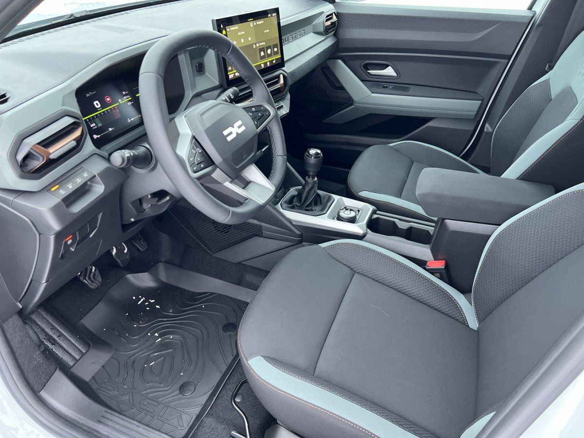 Dacia Innenraum mit Lenkrad, Infotainment-Display und Schaltgetriebe – modernes SUV Cockpit