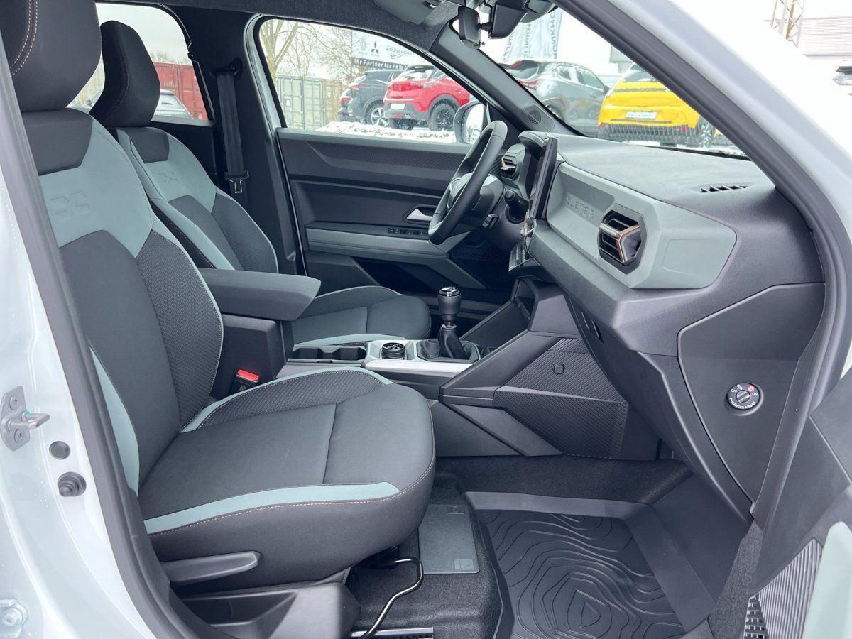 Fahrzeuginnenraum mit schwarzen Sitzen und grauer Akzentfarbe, Schaltgetriebe und modernes Cockpit-Design