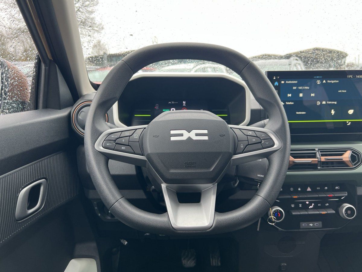 Dacia Innenraum mit Lenkrad, digitalem Cockpit und Infotainment-Touchscreen im Autohaus