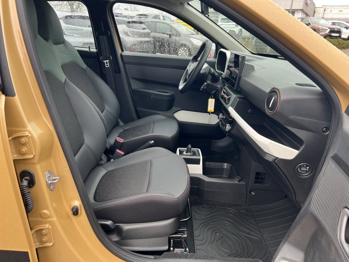 Innenraum eines gelben Dacia Sandero – schwarze Sitze, modernes Cockpit mit Touchscreen, Fahrerseite