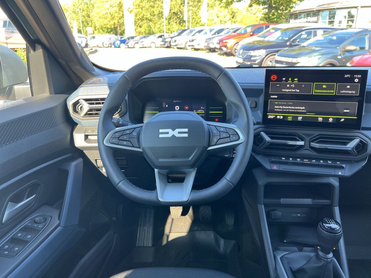 Dacia Innenraum mit Lenkrad, digitalem Cockpit und Infotainment-Display im Autohaus