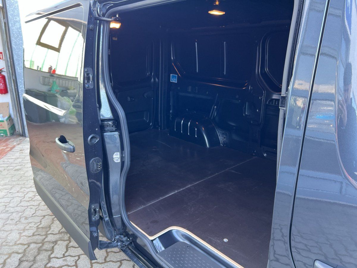 Grauer Transporter mit geöffneter Schiebetür und leerem Laderaum im Autohaus