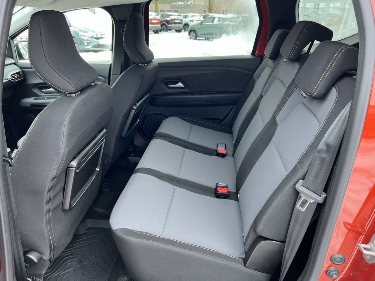 Rücksitzbank mit grau-schwarzen Stoffsitzen im Innenraum eines Dacia Fahrzeugs im Autohaus