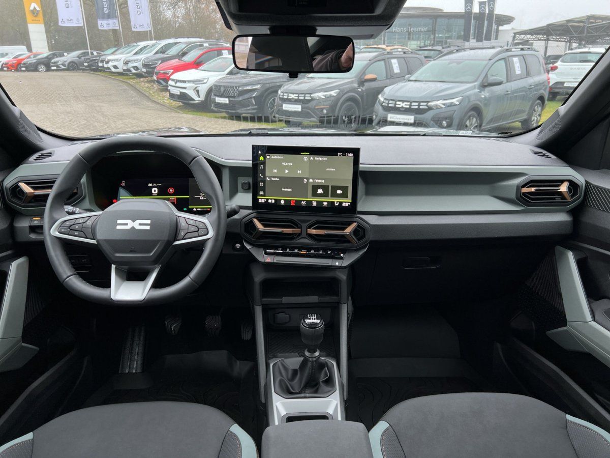 Dacia Innenraum mit Lenkrad, Touchscreen-Infotainment und manuellem Schaltgetriebe im Autohaus