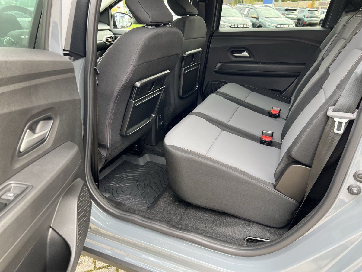 Rücksitzbank mit grauem Stoffbezug und Sitzfach-Taschen im Fond eines silbernen SUV im Autohaus