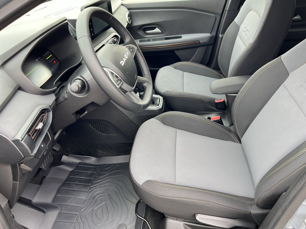 Dacia Innenraum mit Stoffsitzen in Grau-Schwarz, Lenkrad und Infotainment im Autohaus