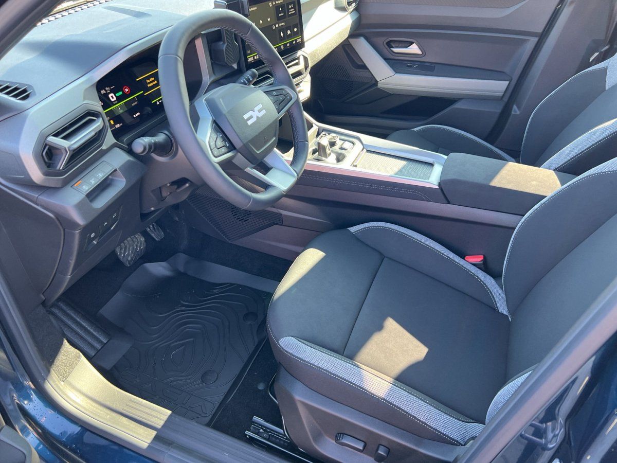 Dacia Innenraum mit Lederlenkrad, Digitaldisplay und modernem Cockpit im Autohaus