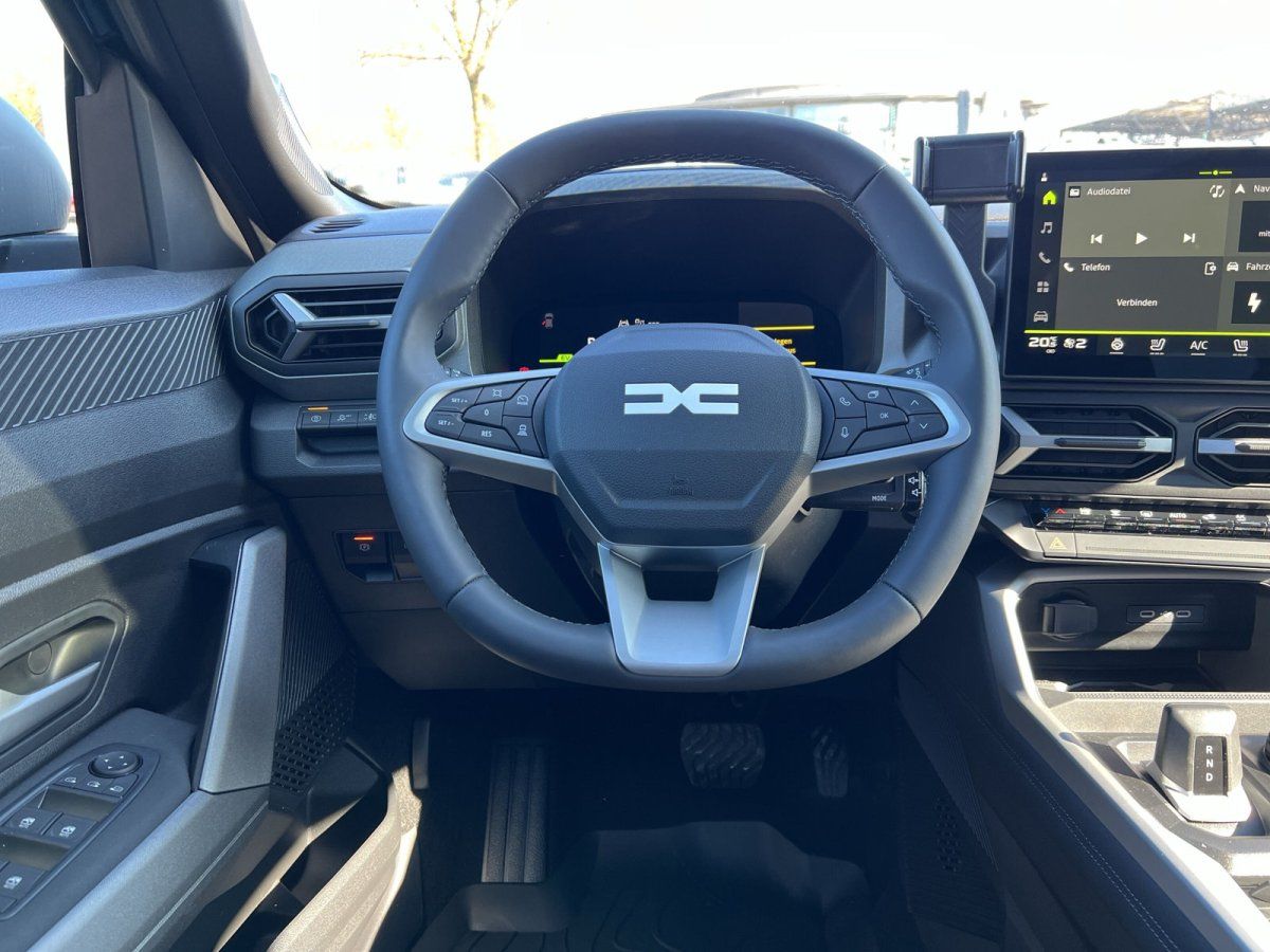Dacia Innenraum mit Lenkrad, digitalem Cockpit und Touchscreen-Infotainment im Autohaus