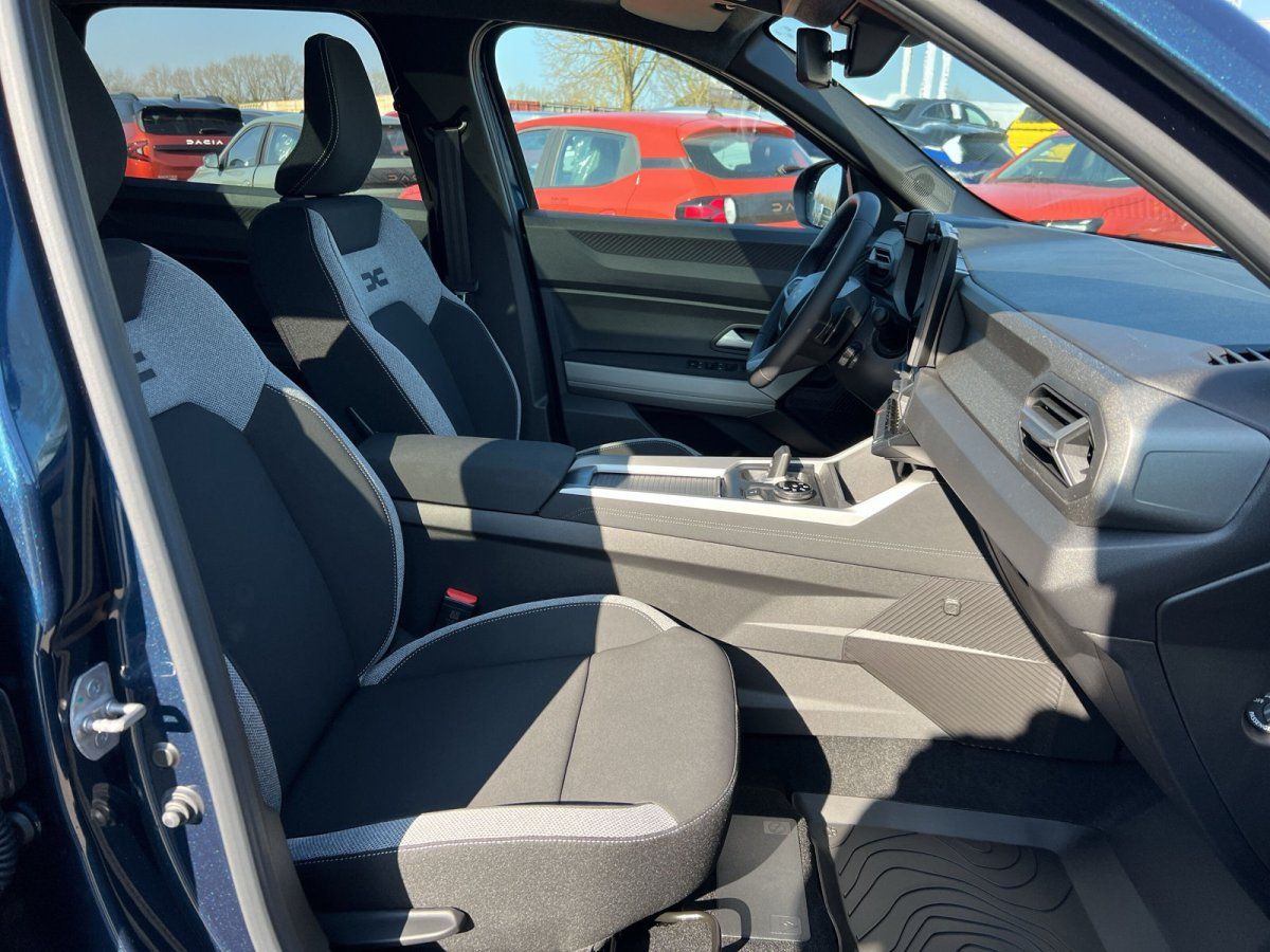 Dacia Innenraum mit grauen Sportsitzen, Mittelkonsole und Lenkrad im Autohaus