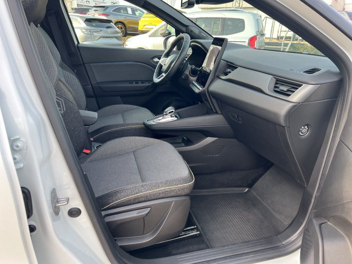 Fahrzeuginnenraum mit grauen Stoffsitzen, modernem Cockpit und digitalem Display