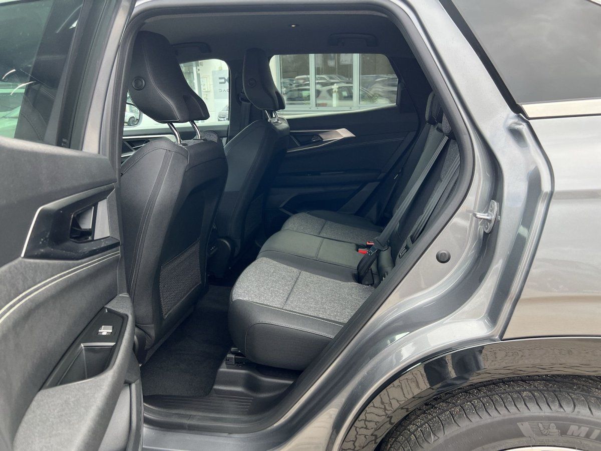 Fahrzeug Rücksitzbank mit grauen Stoffsitzen und offenen Türen im Autohaus Showroom