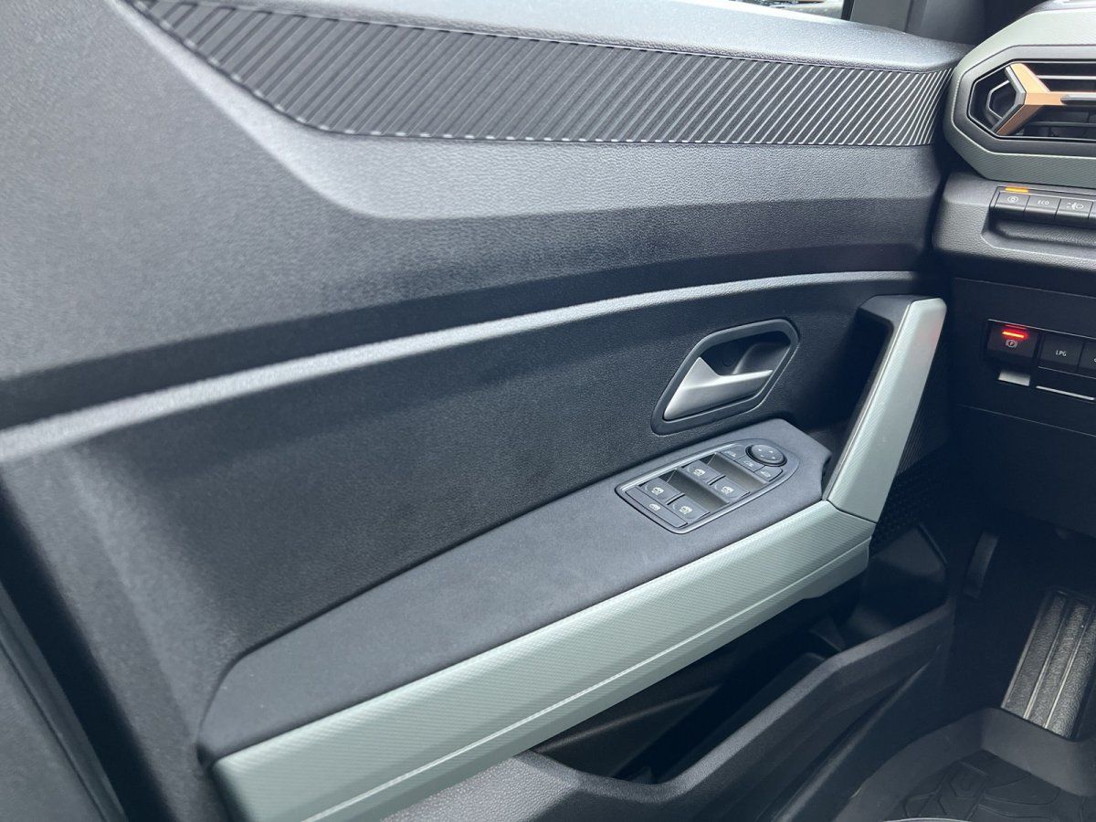 Geöffnete Fahrertür eines silbernen PKW im Autohaus-Showroom mit Blick auf Türverkleidung