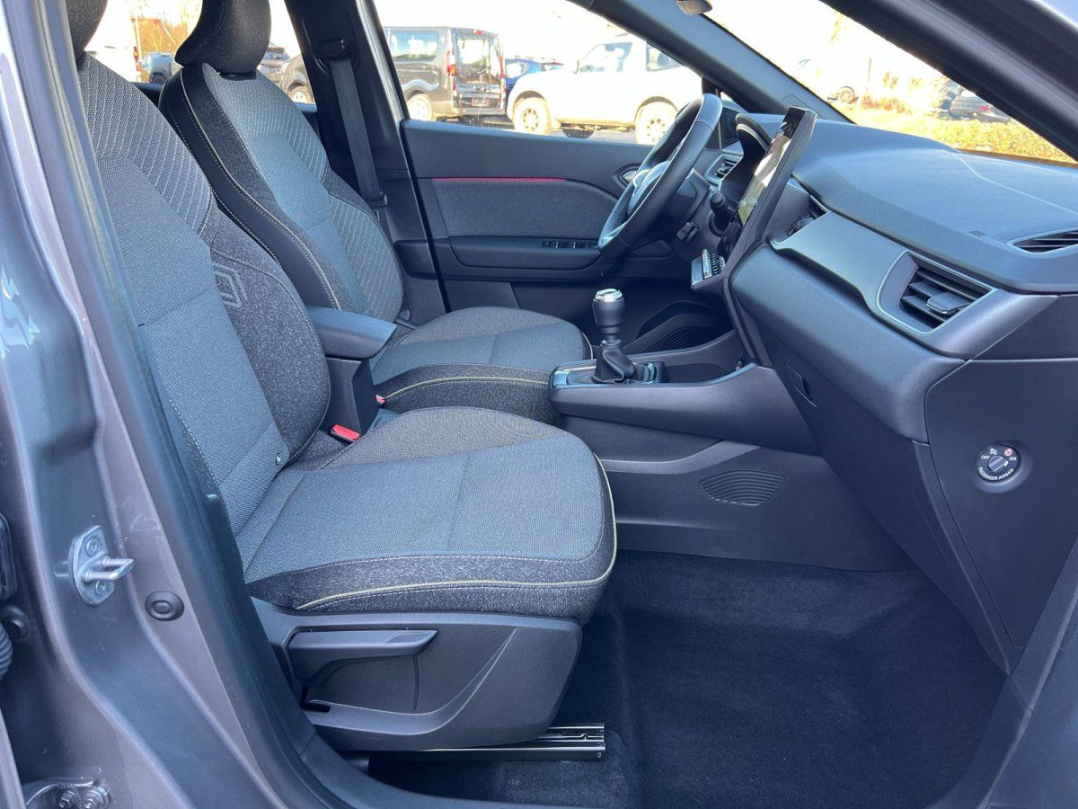 Fahrzeuginnenraum mit grauen Stoffsitzen, Mittelkonsole und Schaltgetriebe – modernes Kompaktauto