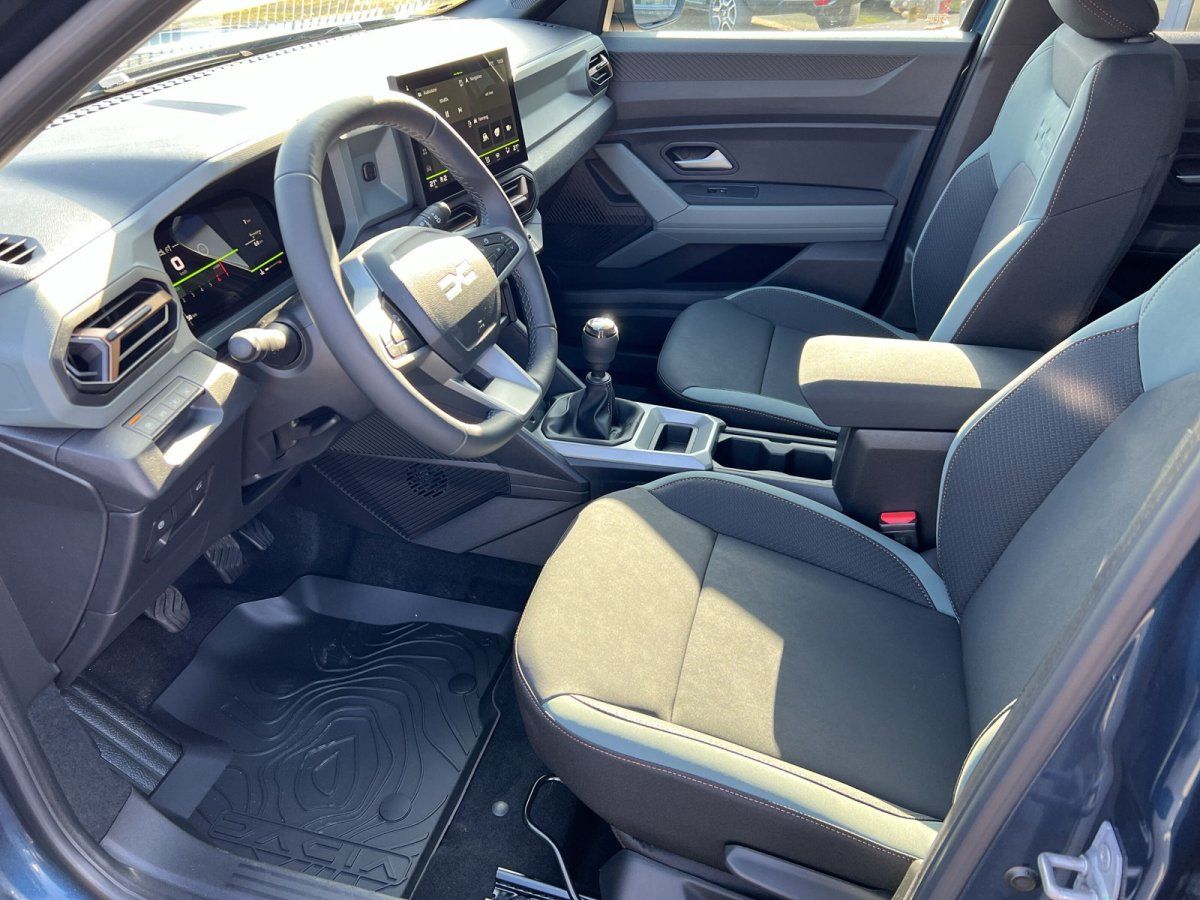 Dacia Innenraum mit Lenkrad, Infotainment-Display und Schaltgetriebe – moderne Fahrzeugausstattung