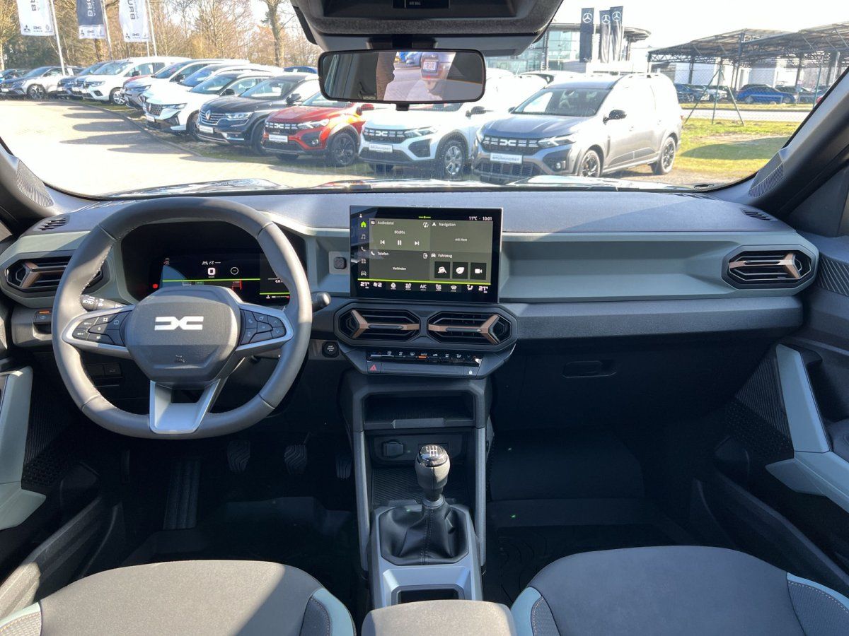 Dacia Innenraum mit Lenkrad, Infotainment-Display und Schaltgetriebe im Autohaus