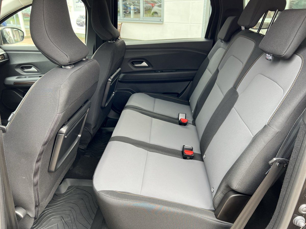 Dacia Rücksitzbank mit grauen Polstern und Sicherheitsgurten im Fahrzeuginnenraum