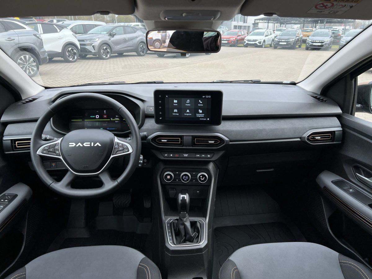 Dacia Innenraum mit schwarzem Armaturenbrett, Touchscreen und Panorama-Schiebedach im Autohaus