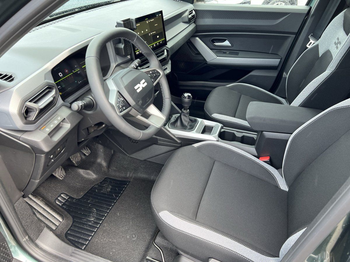 Dacia Fahrzeug Innenraum mit schwarzem Interieur, Lenkrad und modernem Infotainment-Display