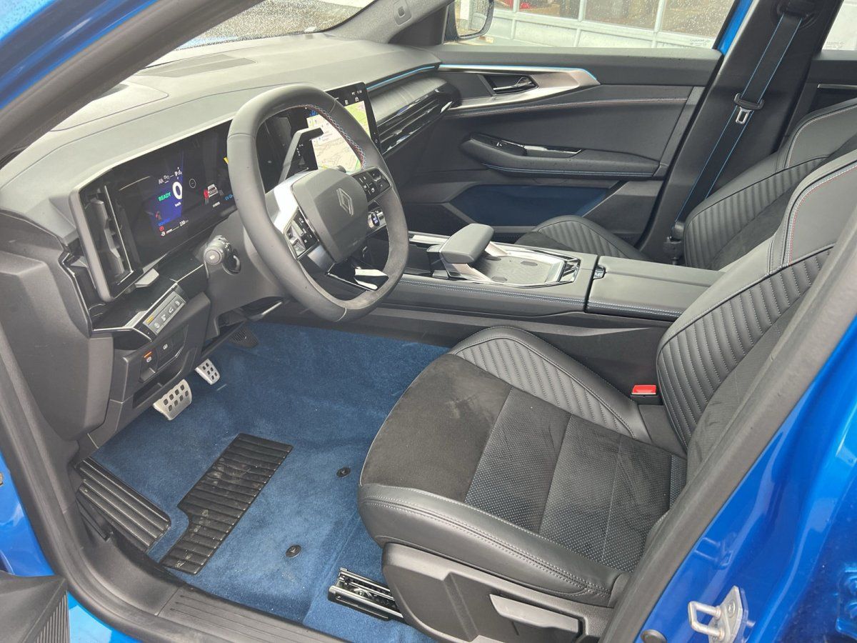 Renault Innenraum mit digitalem Cockpit, schwarzen Ledersitzen und blauem Teppich
