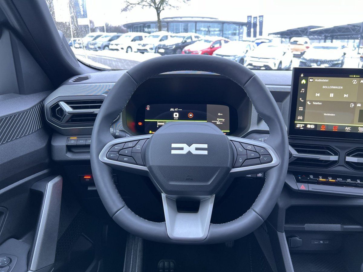 Dacia Innenraum mit Lenkrad, digitalem Cockpit und Infotainment-Touchscreen im Autohaus