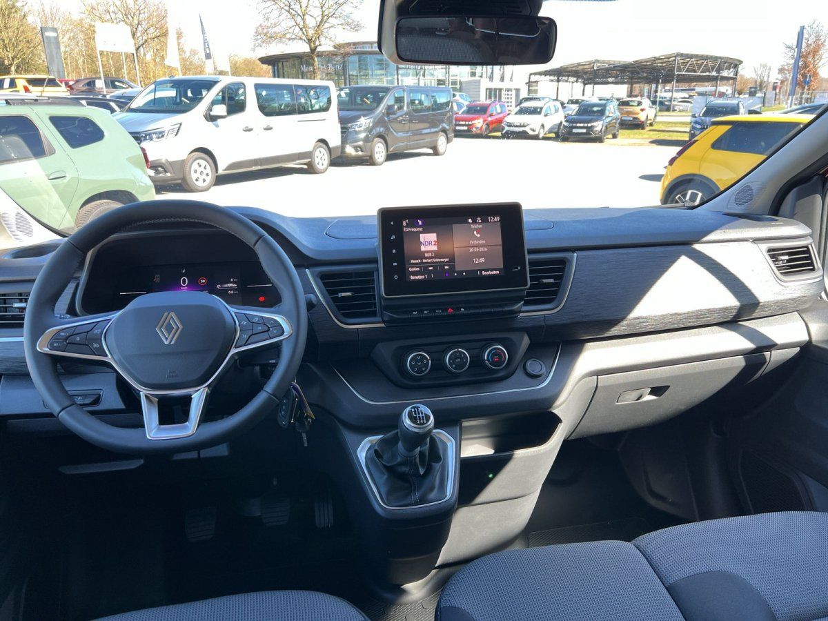 Renault Fahrzeug Innenraum mit Lenkrad, Touchscreen und Blick auf Autohaus Showroom