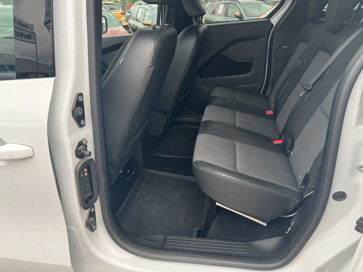 Fahrzeug Innenraum Rücksitzbereich mit schwarzen Ledersitzen und geöffneter Schiebetür im Autohaus