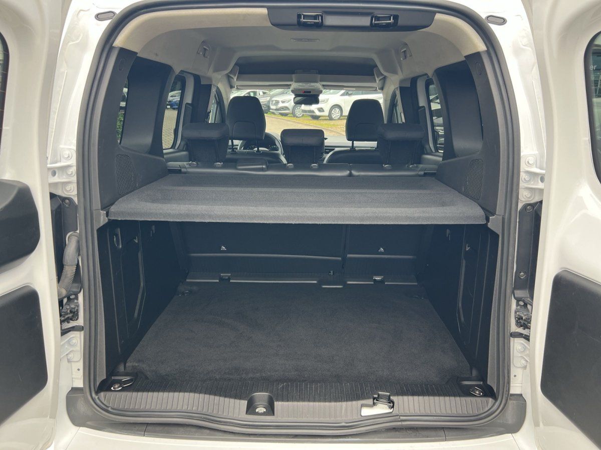 Weißer Kleinbus mit geöffneter Heckklappe im Autohaus-Showroom, Laderaum-Ansicht