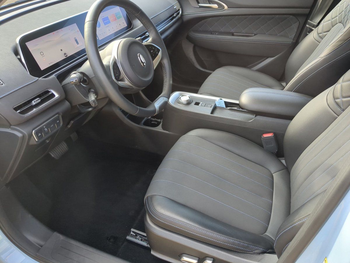 Modernes Fahrzeug Innenraum mit schwarzem Leder, Digitaldisplay und Sportlenkrad im Autohaus