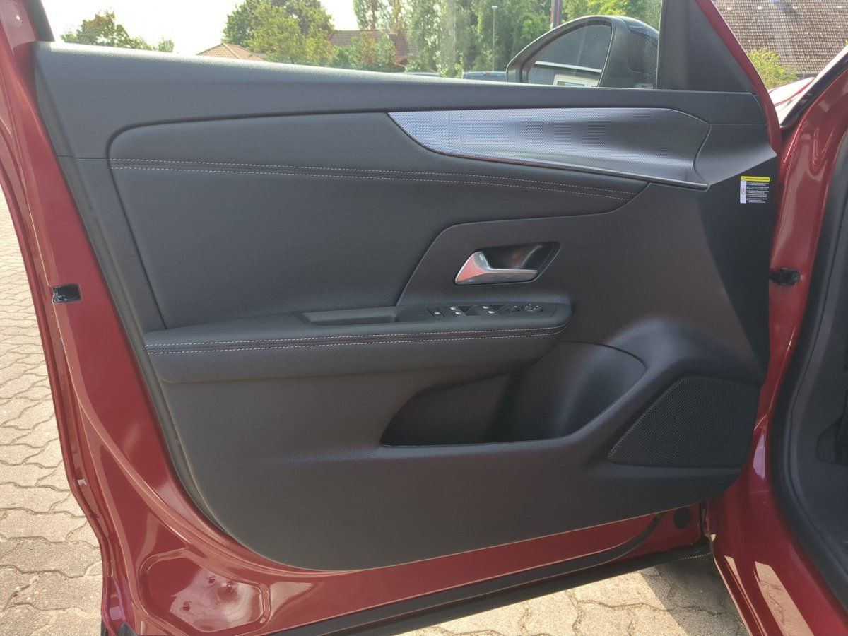 Rotes Fahrzeug Innenraum – Fahrertür mit schwarzer Verkleidung und Fensterheber im Autohaus