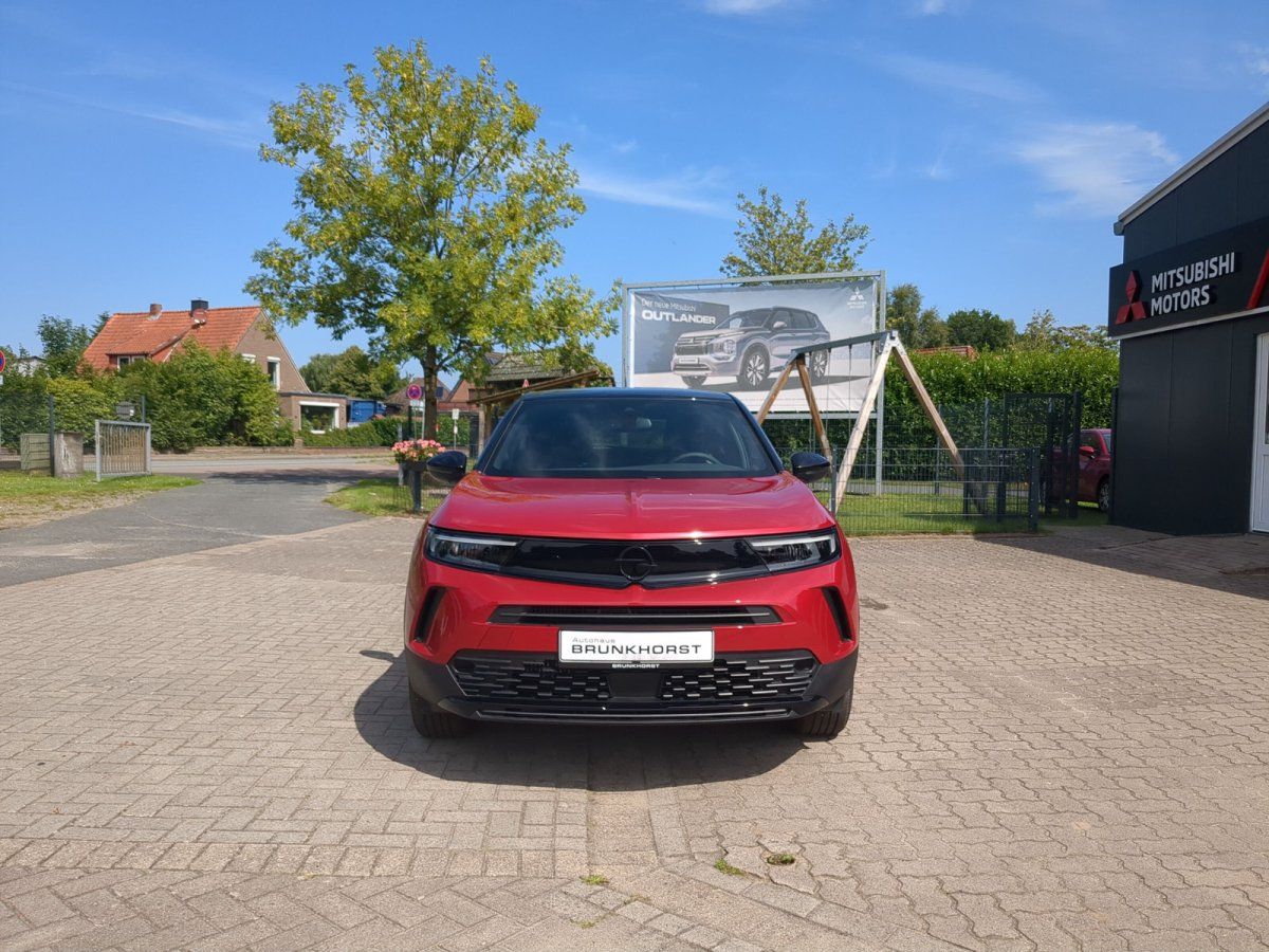 Roter SUV im Autohaus Brunkhorst Showroom, umgeben von schwarzem und silbernem Mitsubishi