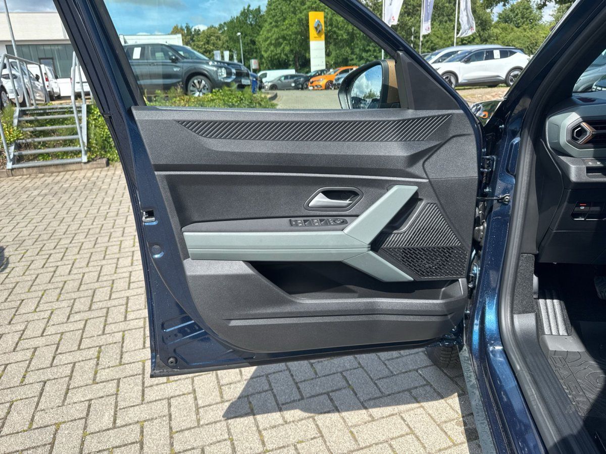 Geöffnete Fahrertür eines dunkelblauen SUV mit modernem Türverkleidung-Design im Autohaus