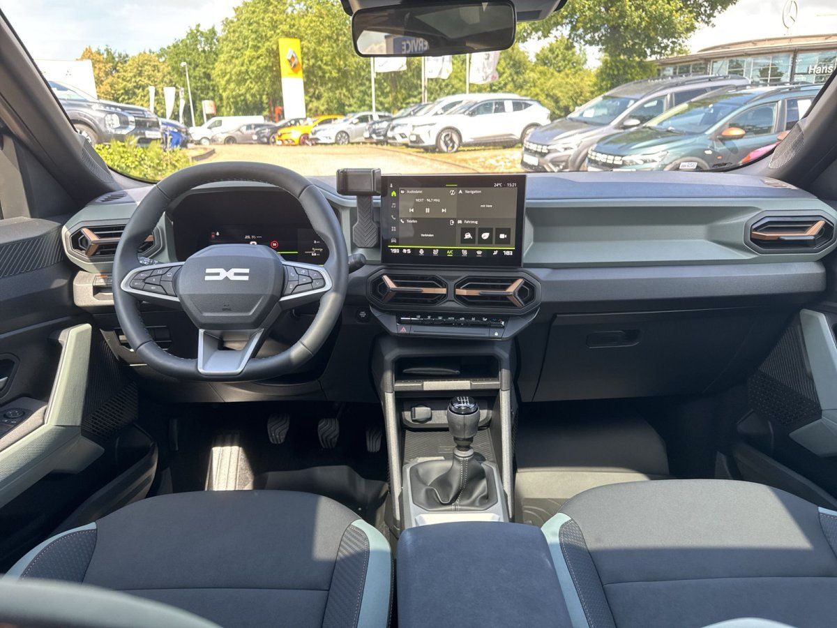 Dacia Innenraum mit Lenkrad, Touchscreen und Schaltgetriebe im Autohaus
