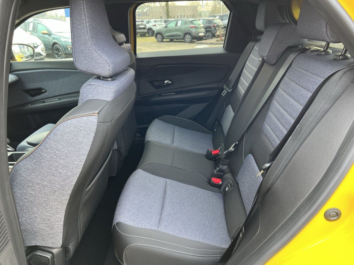 Rücksitzbank mit grauem Stoffbezug im gelben Kompaktwagen im Autohaus-Showroom