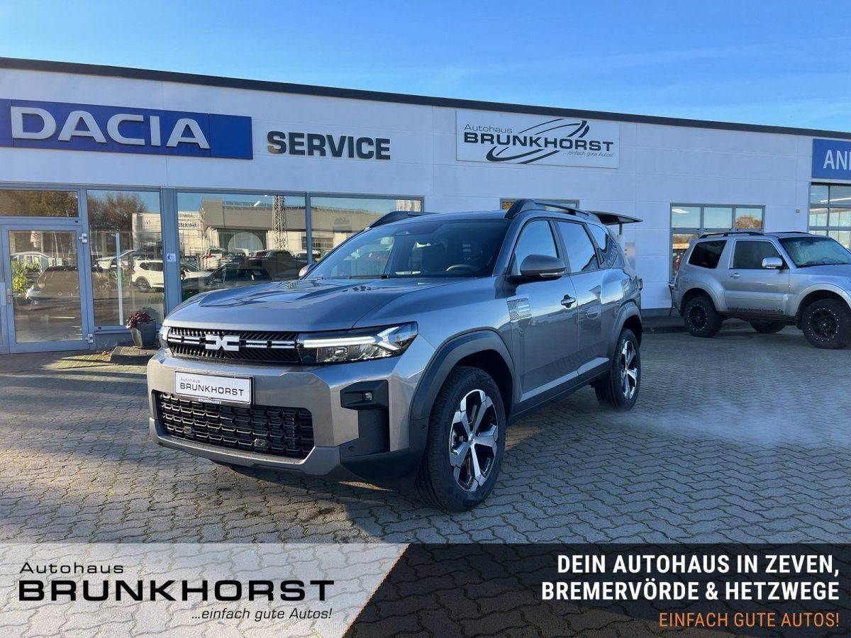 Dacia SUV grau metallic im modernen Autohaus Showroom - Frontansicht mit Designelementen