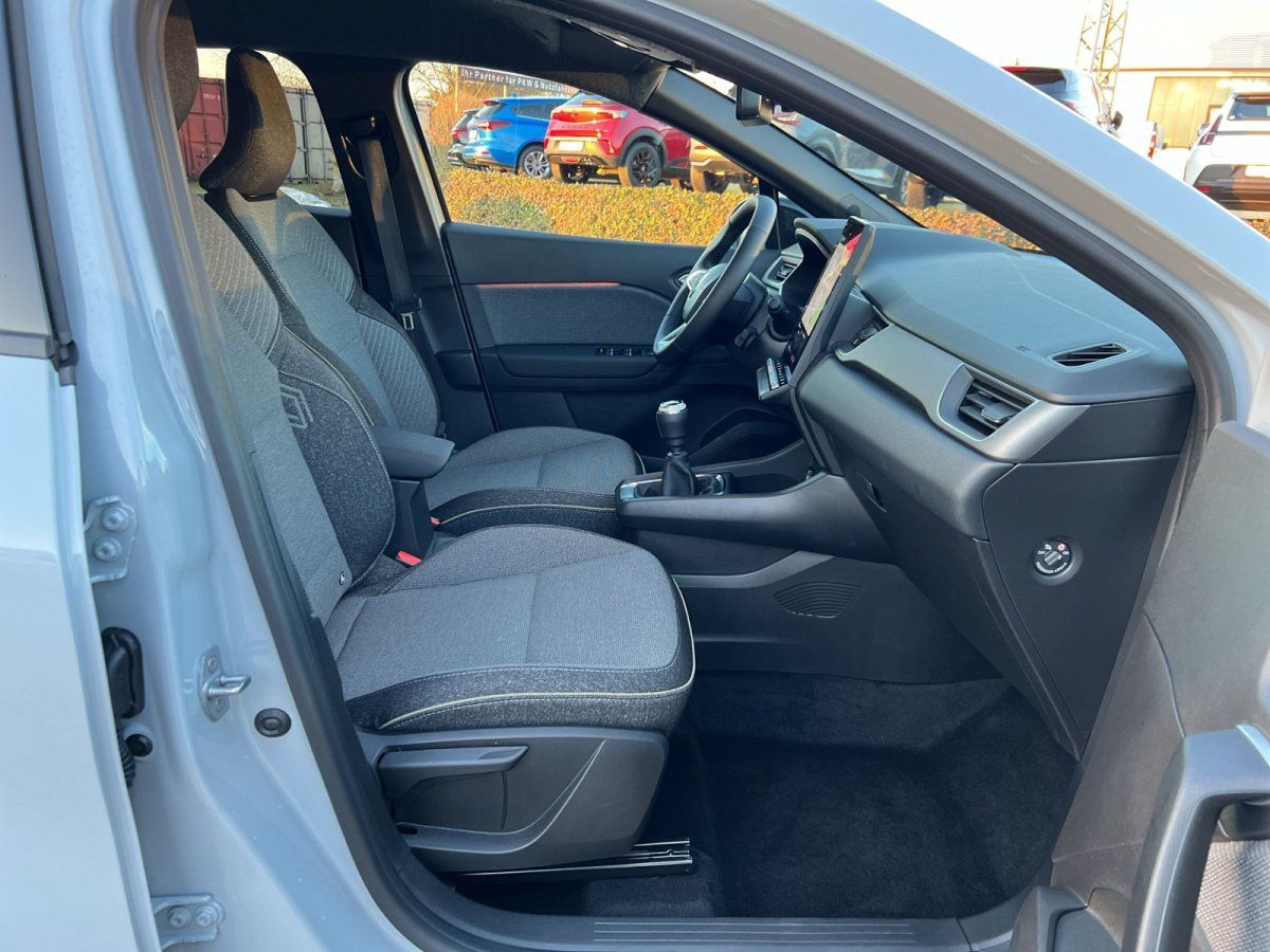 Fahrzeuginnenraum mit schwarzen Stoffsitzen, Mittelkonsole und Touchscreen-Infotainment im Autohaus