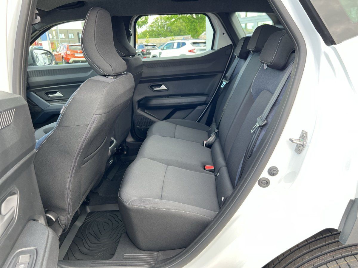 Innenraum Rücksitzbank eines weißen SUV mit schwarzen Stoffsitzen und Sicherheitsgurten