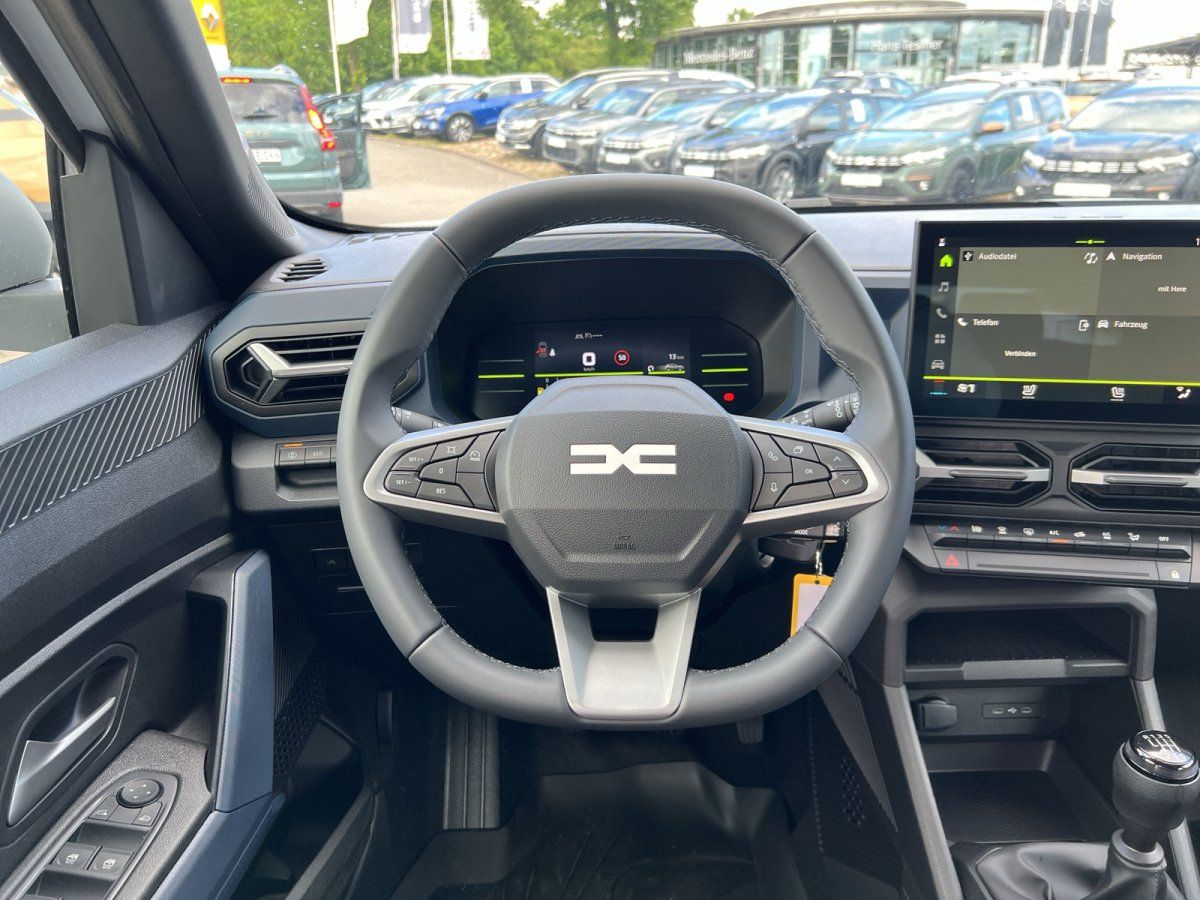 Dacia Innenraum mit Lenkrad, digitalem Cockpit und Touchscreen-Infotainmentsystem im Autohaus