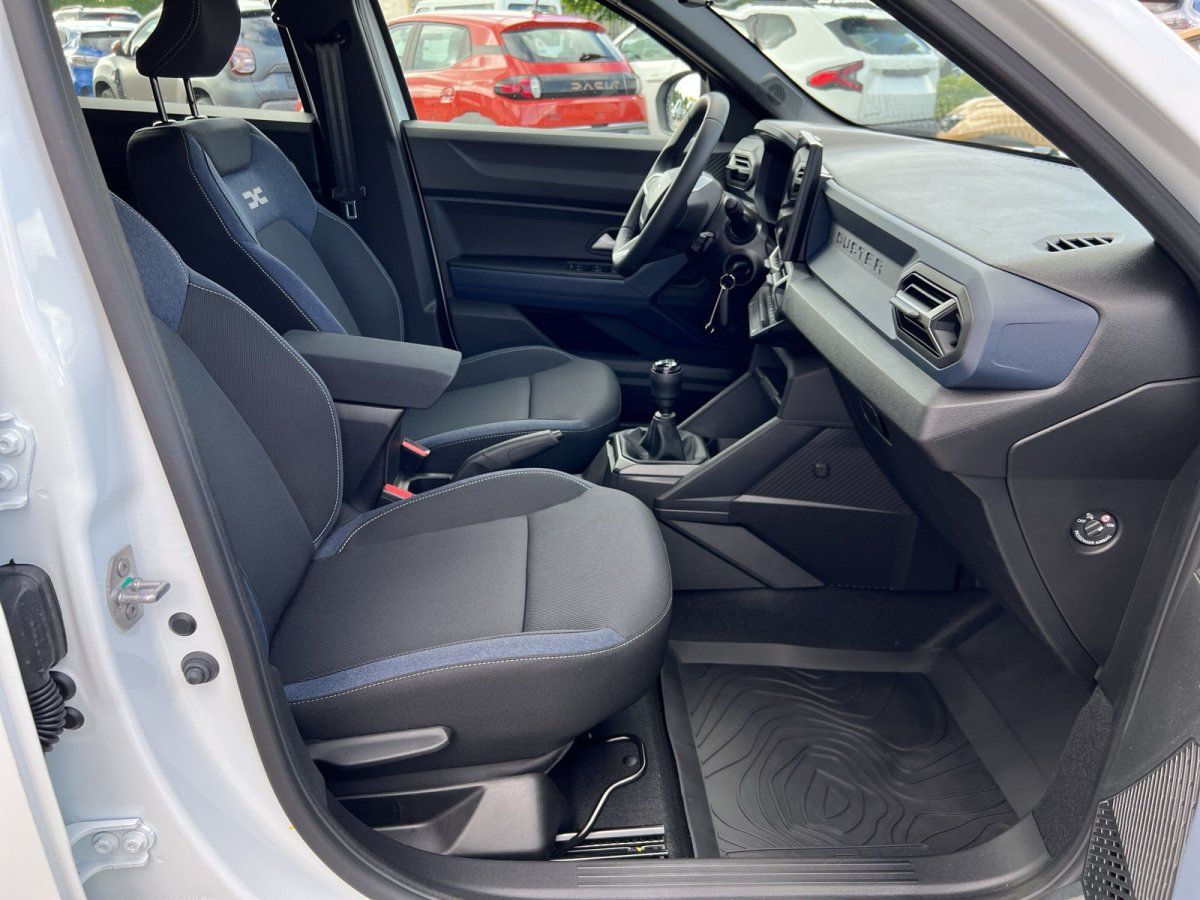 Dacia Duster Innenraum mit schwarzen Stoffsitzen, Mittelkonsole und Schaltgetriebe