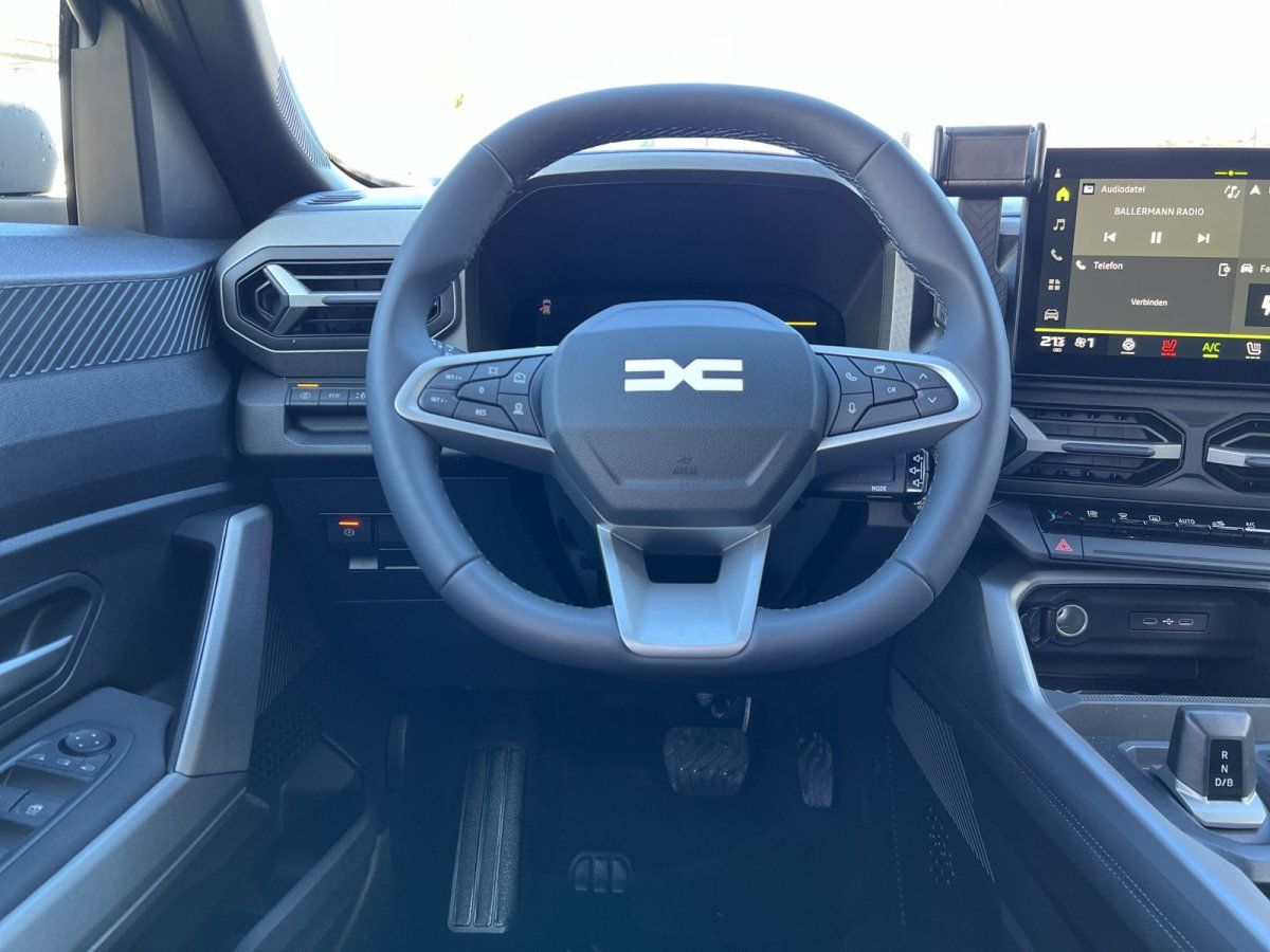 Cockpit-Ansicht mit Lenkrad, Armaturenbrett und Touchscreen-Display im Fahrzeuginnenraum