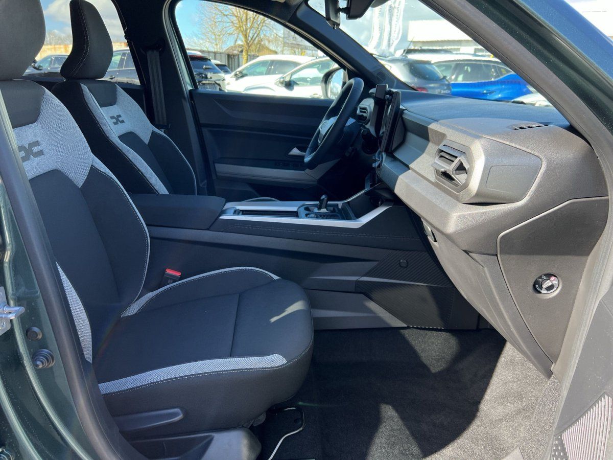 Fahrersitz und Innenraum eines Fahrzeugs mit grau-weißer Polsterung im Autohaus